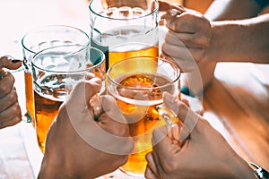 Friends toasting with glasses of light beer at the pub.