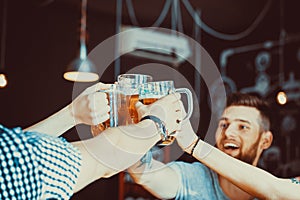 Friends toasting with glasses of light beer at the pub.