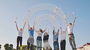 Friends toss colorful paper confetti from their hands.