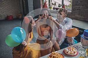 Friends touching womens cheeks during the birthday party