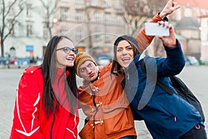 Friends in a touristic city center, taking a selfie.