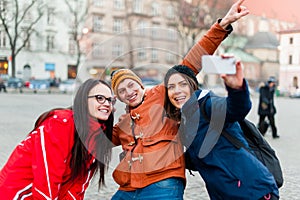 Friends in a touristic city center, taking a selfie.