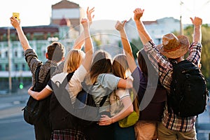 Friends tourists with backpacks rising hands