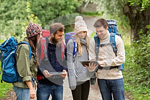 Friends or travelers with backpacks and tablet pc