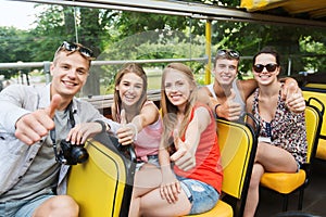 Friends traveling by tour bus showing thumbs up