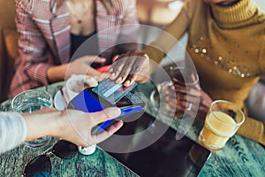 Friends using credit card and making contactless payment in a restaurant