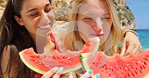 Friends, vacation and eating watermelon at beach, picnic and sea. Summer, holidays and getaway with happy women enjoying