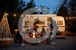 Friends warming themselves by the bonfire, camping