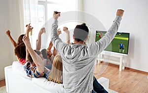 Friends watching soccer on tv and celebrating goal