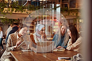 Friends. Women Meeting In Cafe. Group Of Four Smiling Girls Sitting In Restaurant And Discussing.