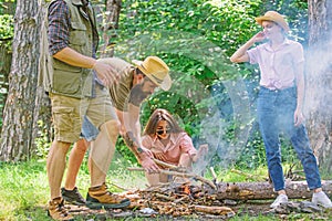 Friends working as team to keep bonfire. Company youth camping forest prepare bonfire for picnic. Add some wood to fire