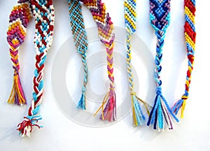 Friendship bracelets made of thread with braids on white background