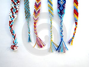 Friendship bracelets made of thread with braids on white background
