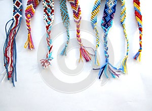 Friendship bracelets made of thread with braids on white background