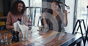 Friendship concept. Three happy young beautiful multiethnic smiling female friends meeting at trendy coffee shop table.
