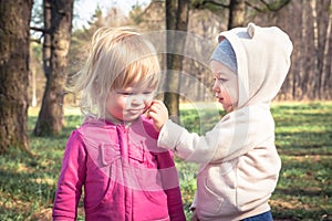 Friendship between cute baby girls playing together in park symbolizing children friendship