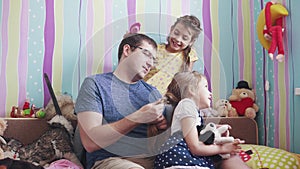 Friendship of the father and daughters. young daddy does pigtails daughters