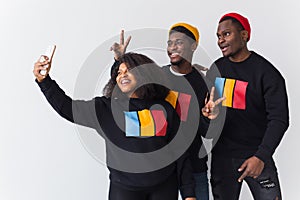 Friendship and fun concept - Group of friends afro american men and woman taking selfie in studio on white background.