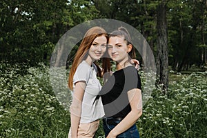 Friendship, Gen Z, Sisters, twins. Two red-haired and brown-haired young women, girlfriends in black and white T-shirt