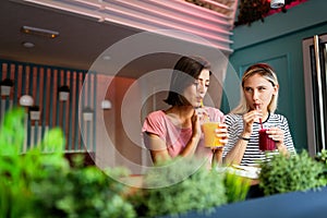 Friendship, happiness and people concept. Young women talking and having fun together