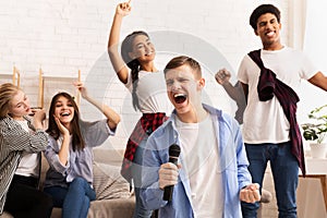 Friendship and home entertainment. Teens singing karaoke