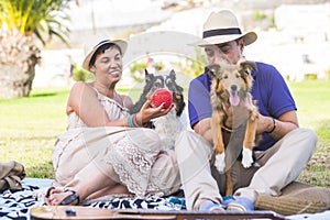 Friendship and love for animals dog concept with couple of young caucasian people at the park with two funny puppy having nice