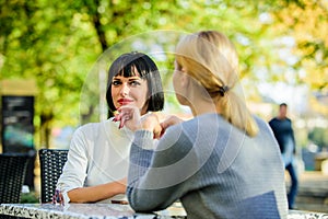 Friendship or rivalry. Girls friends drink coffee talk. Conversation of two women cafe terrace. Friendship friendly