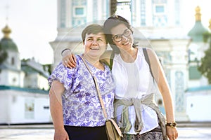 The friendship of two adult women lasts for a very long time Happy friends hug and hold each other, smile. Women travel