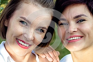 Friendship of women. Two beautiful women of Caucasian appearance are smiling. Close-up portrait