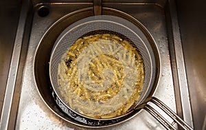 Fries in deep fryer at snack bar