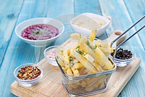 Fries Potato in Basket with Hommos and Red Hommos, Fried Potato with Spices and Arabic Hommos / Hummus / Hummus. On Blue Wood