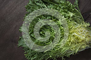 Frieze salad on a dark wooden background. Fresh greens. Place for text