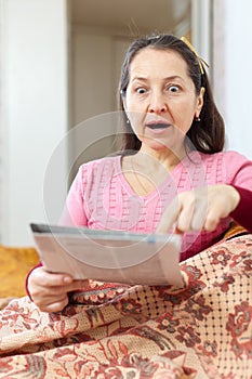 Fright and amazed woman with newspaper