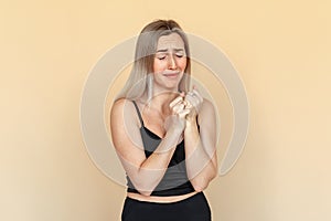 Fright. Portrait of the scared young woman with freckles and close eyes. Worried girl wearing casual black clothes standing over