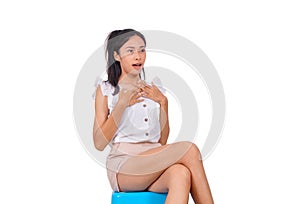 A frighten asian girl in white sitting on blue stool bare feet