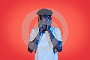 Frightened african american young man covering his face