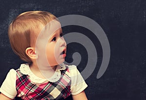 Frightened baby girl with chalk at a school board