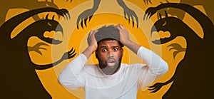 Frightened black guy with open mouth grabbing head in panic on orange background, collage with dark monster shadows