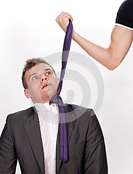 Frightened businessman being pulled by the tie