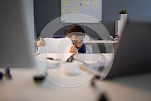 Frightened Businessman Hiding Behind Chair