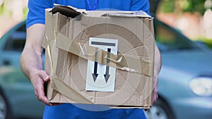 Frightened delivery worker giving broken customer parcel, shipment accident