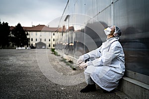 Frightened doctor for infectious diseases having mental nervous break down.Coronavirus COVID-19 exhausted physician in fear. photo