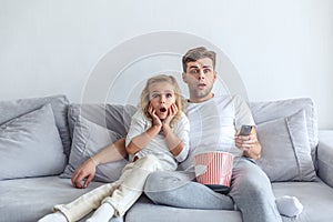 frightened father and daughter watching scarry movie