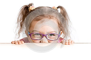 Frightened kid in spectacles looking from under photo