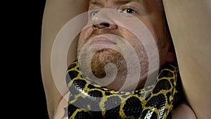 Frightened man with anaconda on his neck