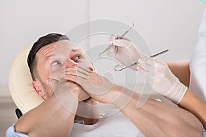 Frightened Man At Dentist Office Covered Mouth With Hands