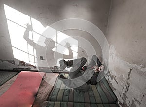 Frightened man terrified guy lying back mattress, ghost shadow window, room