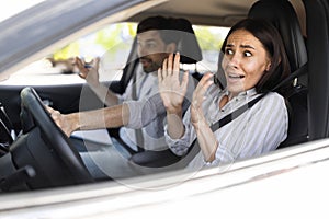 Frightened millennial woman driving car with instructor