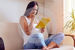 Frightened pregnant woman reading book
