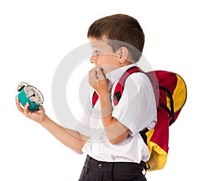 Frightened schoolboy with alarm clock in hand